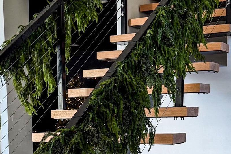 Realistic faux Christmas garland: floating staircase wrapped in full Norfolk pine garland