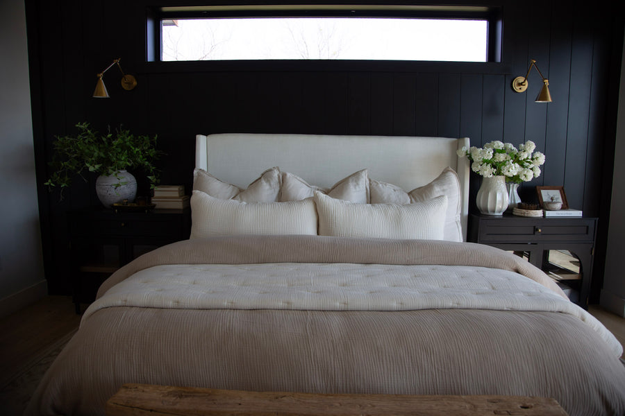 Taupe and white bed against a black wall